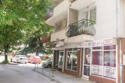 a building on a street with cars parked in front of it at Apartment Eve in Varna City