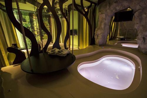 a bathroom with a bath tub with trees in it at Emotional Grand Motel in Fontaneto dʼAgogna