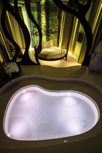 a bath tub in a room with a window at Emotional Grand Motel in Fontaneto dʼAgogna