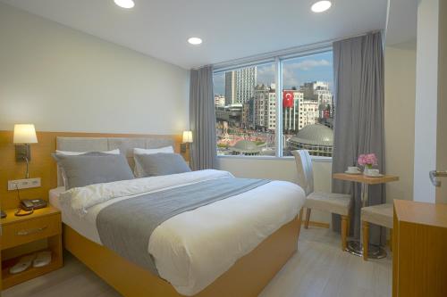 1 dormitorio con cama grande y ventana grande en Kartal Palace Taksim Square FAMİLY HOTEL, en Estambul