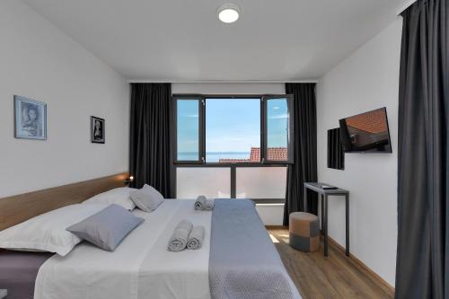 a bedroom with a large bed and a large window at Villa Smart in Veliko Brdo