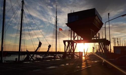 a sun setting over a dock with boats at Slapen in een Trechter in Harlingen