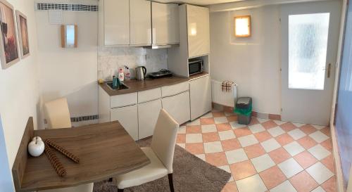 eine Küche mit weißen Schränken und einem Holztisch in der Unterkunft Vila Linda in Luhačovice