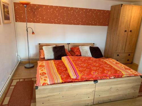 ein Schlafzimmer mit einem großen Holzbett mit Kissen in der Unterkunft Vila Linda in Luhačovice