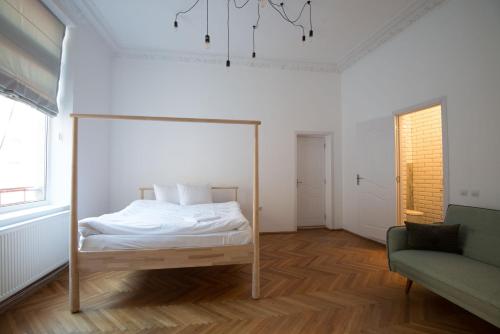 ein Schlafzimmer mit einem Bett und einem Sofa in der Unterkunft George Enescu Suites in Bukarest