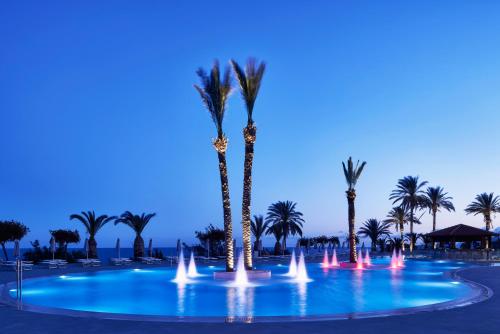 a pool with palm trees and a fountain at Rodos Princess Beach Hotel in Kiotari