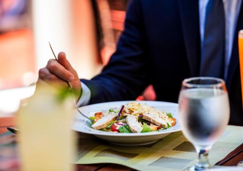 a person sitting at a table with a plate of food at Lancaster Tamar Hotel- Hadath in Beirut