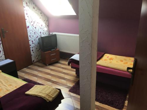 Kleines Zimmer mit 2 Betten und einem TV in der Unterkunft Restauracja Łania in Koszalin