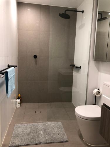 a bathroom with a shower with a toilet and a sink at Skyview Apartment in Liverpool in Liverpool