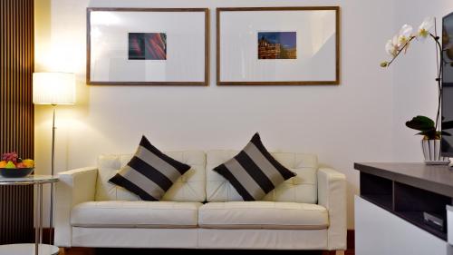 a living room with a white couch with two pillows at Residence26 in Yangon