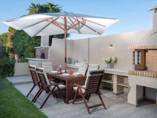 a table and chairs with an umbrella on a patio at Evdokia Beach Resort in Gázion