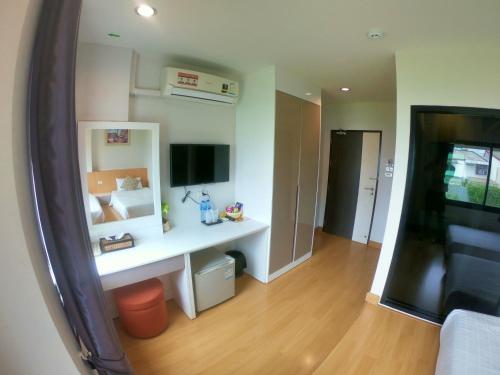 a living room with a desk and a television at Klongrien Boutique Hotel in Hat Yai