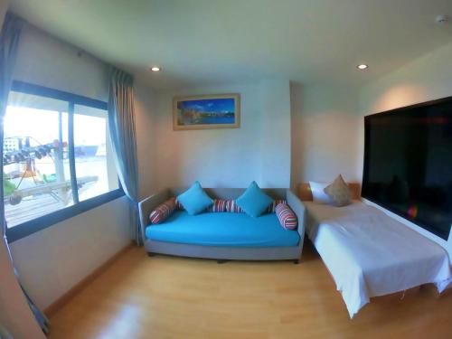 a living room with a blue couch and a tv at Klongrien Boutique Hotel in Hat Yai