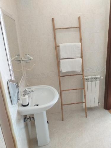 a bathroom with a sink and a towel ladder at Villa Vittorio in Infernetto