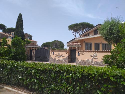 a house with a fence in front of it at Villa Vittorio in Infernetto