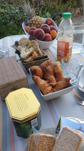une table avec différents types de pain et autres denrées alimentaires dans l'établissement Au calme chez l'habitant, à Foulayronnes