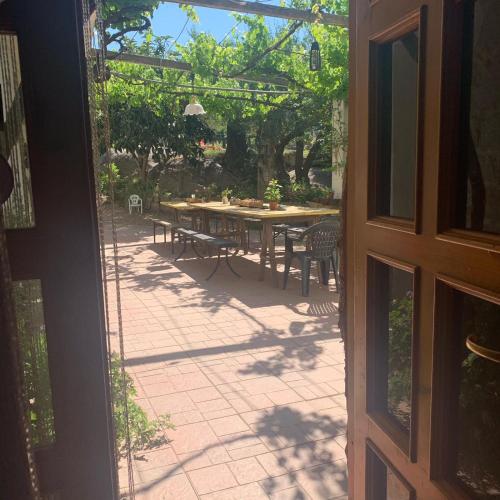 an open door to a patio with a table and chairs at S'Imbragu Farm B&B in Tortolì