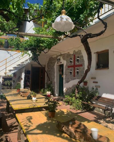 a table in the courtyard of a house with a tree at S'Imbragu Farm B&B in Tortolì