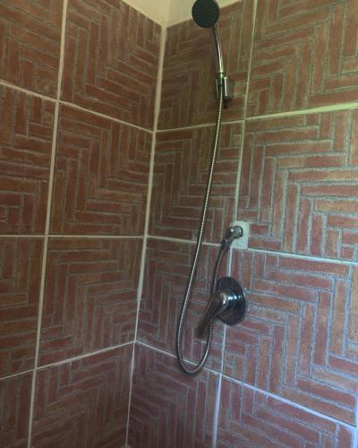 a shower in a bathroom with a wooden tile wall at S'Imbragu Farm B&B in Tortolì