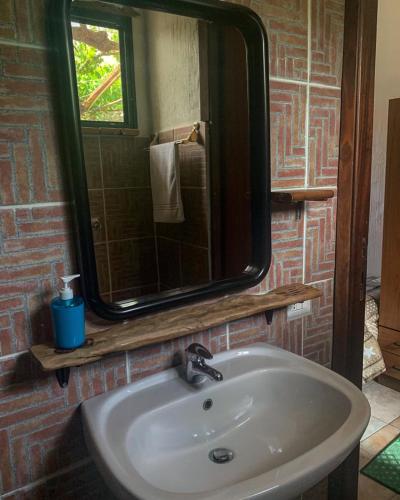 a bathroom sink with a large mirror above it at S'Imbragu Farm B&B in Tortolì