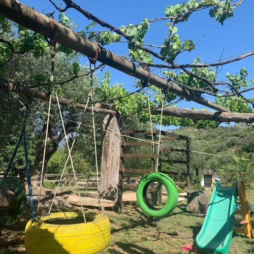 a playground with two swings and a tire swing at S'Imbragu Farm B&B in Tortolì