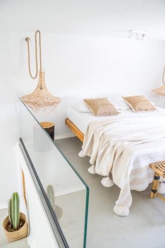 a bedroom with two beds and a glass table at Euphoria Chora Naxos in Naxos Chora