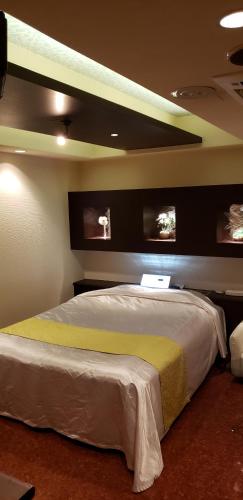 a bedroom with a bed with two monitors on the wall at HOTEL KAZAN (Adult Only) in Iwaki