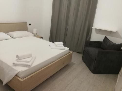 a bedroom with a bed and a chair at B&B Crispino in Belvedere Marittimo