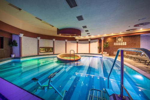 ein großer Swimmingpool in einem Hotelzimmer in der Unterkunft Hotel Therma Dunajská Streda in Dunajská Streda