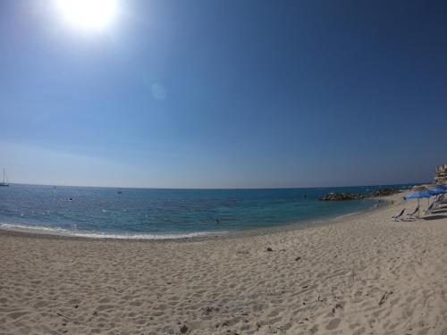a beach with chairs and umbrellas and the ocean at Residenza Gherly in Capo Vaticano