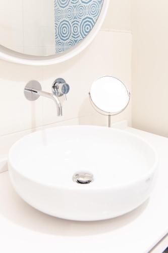 a white bathroom sink in front of a mirror at Hotel Club Due Torri in Maiori