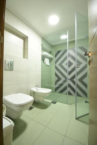 a bathroom with a toilet and a sink and a shower at Brazilia Suites Hotel in Baabda