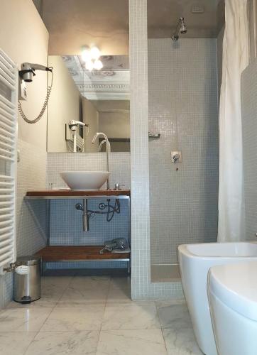 a bathroom with a sink and a tub and a toilet at Villa Ottocento in Campertogno