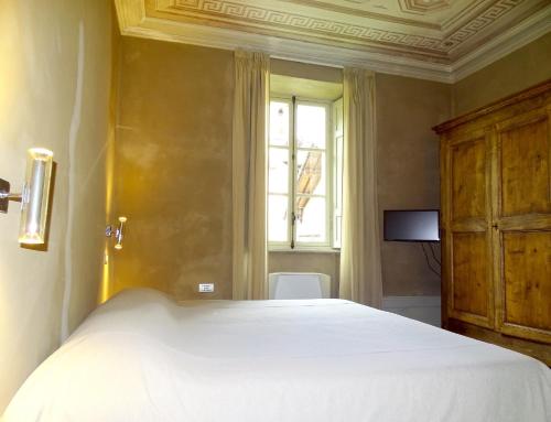 a bedroom with a white bed and a window at Villa Ottocento in Campertogno