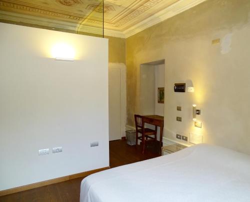 a bedroom with a white bed and a table at Villa Ottocento in Campertogno