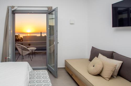 a bedroom with a couch and a view of a patio at Oro Suites in Kinion