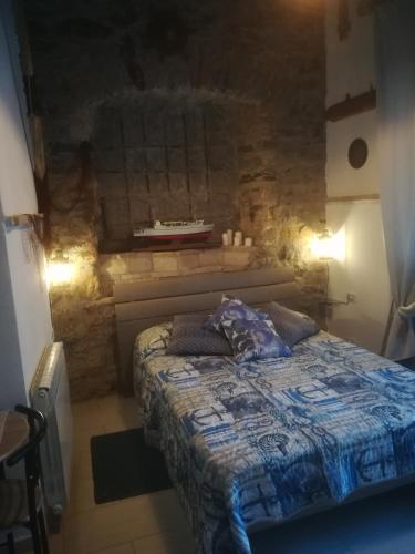 a bedroom with a bed and a stone wall at affittacamere BABY in La Spezia
