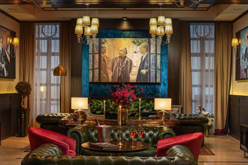 a lobby with leather furniture and a painting on the wall at Epoque Hotel - Relais & Chateaux in Bucharest