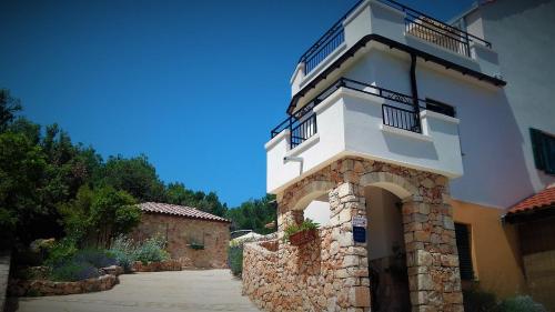a white building with a balcony on top of it at Lavender Hill Hvar Villa - pool, jacuzzi,sauna,BBQ in Stari Grad