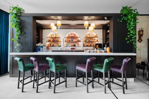 a bar with green and purple bar stools at Epoque Hotel - Relais & Chateaux in Bucharest