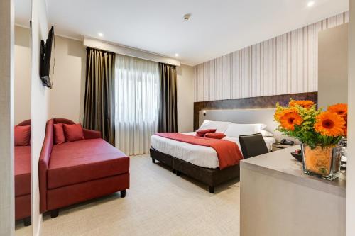 Pokój hotelowy z łóżkiem i czerwonym krzesłem w obiekcie Eurogarden Hotel w Rzymie
