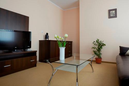 a living room with a vase of flowers on a table at Pokoje Gościnne WSAP in Ostrołęka
