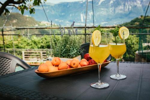 un tavolo con un cesto di frutta e due bicchieri di vino di Casa Federico a Tremosine Sul Garda