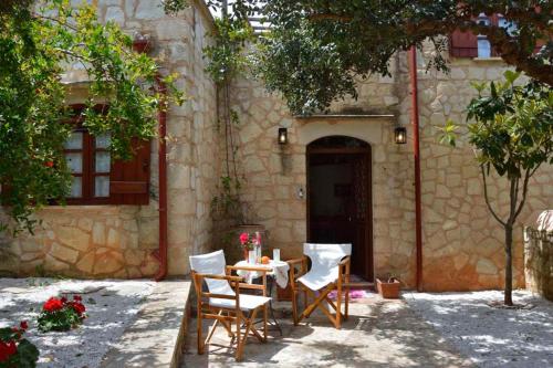 a table and chairs in front of a building at Apanemia in Vamos