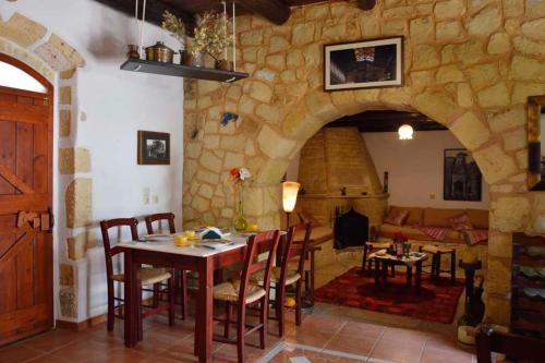 a living room with a table and a stone wall at Apanemia in Vamos