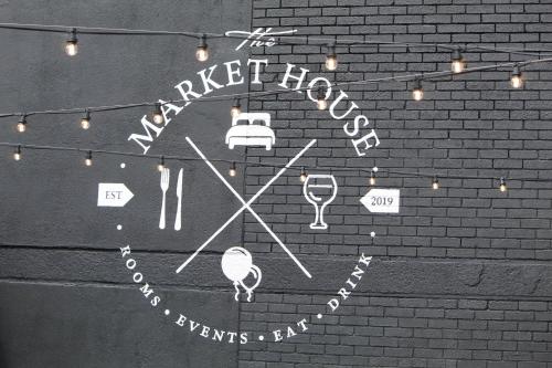 a clock on the side of a brick wall with lights at The Market House in Reading
