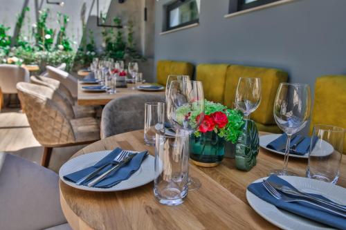 a wooden table with glasses and napkins and flowers on it at Reverence Boutique Hotel in Varna City