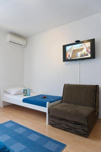 a bedroom with a bed and a couch and a tv at Apartment Maša in Trebinje