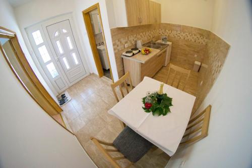 a small kitchen with a white table with flowers on it at Apartment Maša in Trebinje