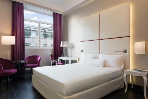 a hotel room with a bed and a window at Sina De La Ville in Milan